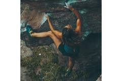 Image Woman climbing a rock face.